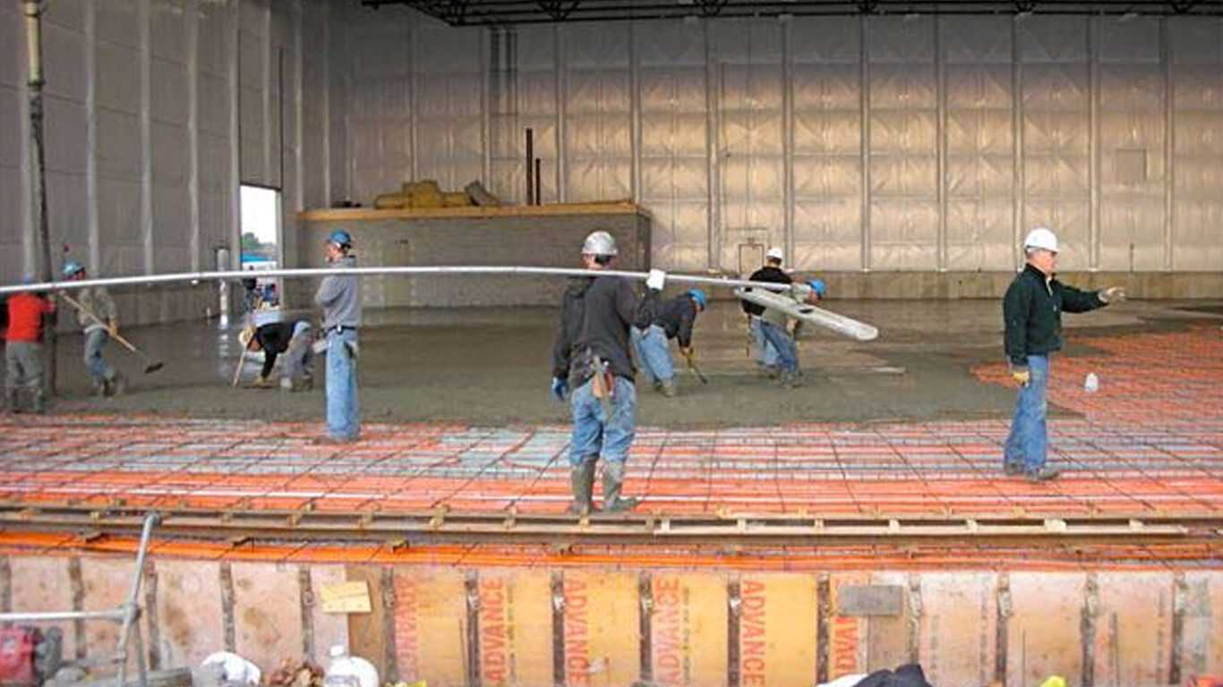 Men assembling floor heating for airplane hangar.