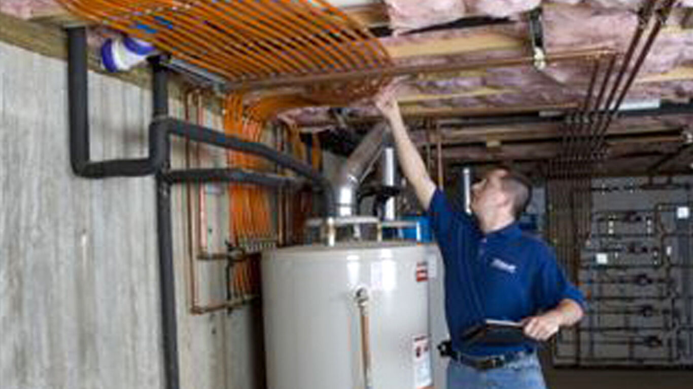 Man in basement of house checking on his installing job of radiant heating